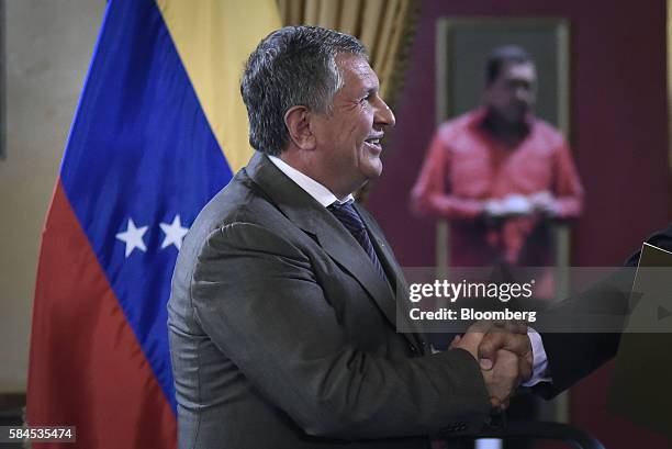 Igor Sechin, chief executive officer of Rosneft PJSC, shakes hands with Nicolas Maduro, president of Venezuela, not pictured, after signing natural...