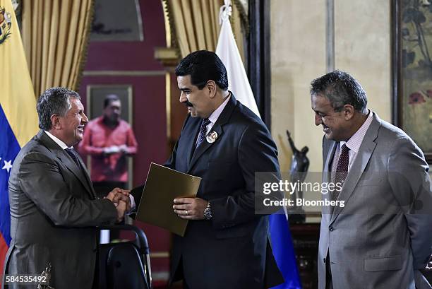 Igor Sechin, chief executive officer of Rosneft PJSC, left, shakes hands with Nicolas Maduro, president of Venezuela, center, as Eulogio del Pino,...