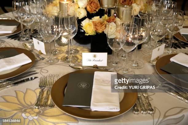 Table settings are viewed in the State Dining Room of the White House in Washington, DC on July 29 in advance of the state dinner honoring the visit...