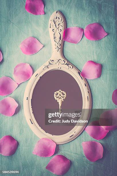 hand mirror with ornate key and pink rose petals on aqua background - ornate key stock pictures, royalty-free photos & images