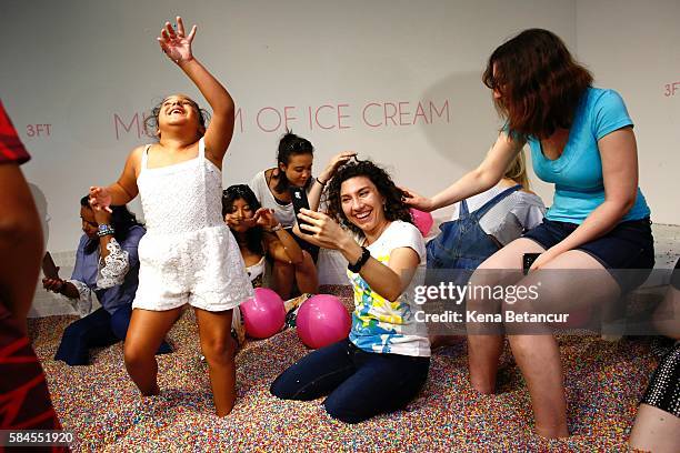 Visitors play into a large pool filled with faux confetti-colored sprinkles at the Museum of Ice Cream across from the Whitney Museum on July 29,...