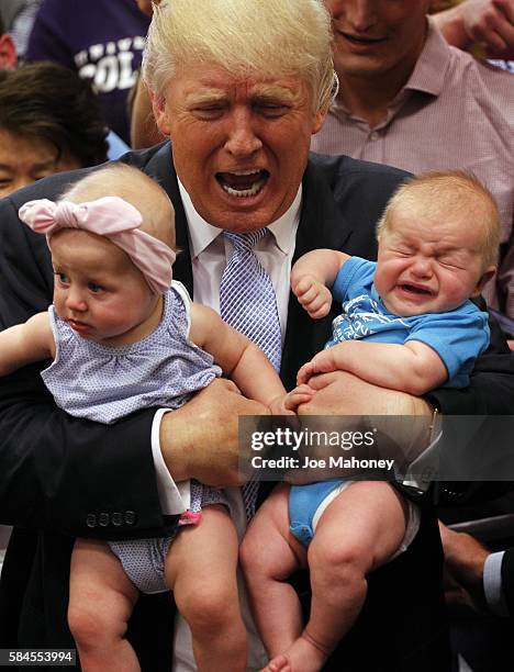 Republican presidential nominee Donald Trump reacts to the cries of three-month-old Kellen Campbell, of Denver, right, while holding six-month-old...