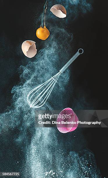levitating kitchen utensils in a cloud of flour - ballonklopper stockfoto's en -beelden