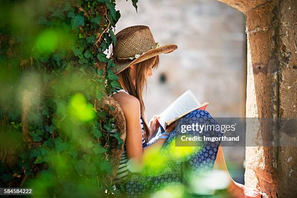 teenage girl reading a book in old garden. - memorial garden stock pictures, royalty-free photos & images