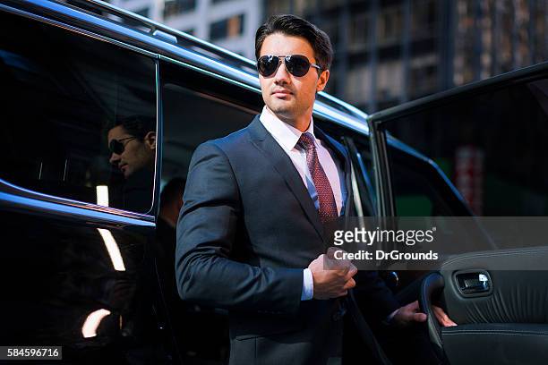 handsome businessman arriving in executive car - wealth lifestyle stock pictures, royalty-free photos & images
