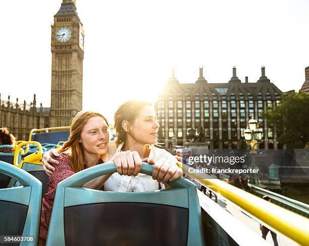 lesbisches touristenpaar machen eine tour in london - london buses stock-fotos und bilder