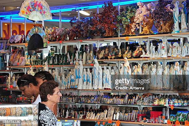 People buying religious souvenirs in souvenir shop near the Sanctuary of Our Lady of Lourdes, Pyrenees, France.