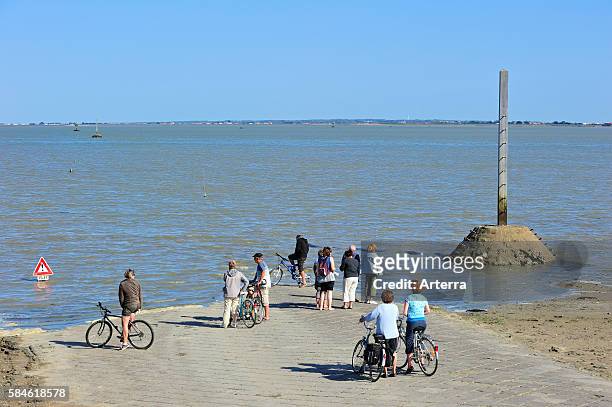 Tourists waiting for low tide to uncover the Passage du Gois / Goa causeway from the ile de Noirmoutier to Beauvoir-sur-Mer, La Vendee, Pays de la...