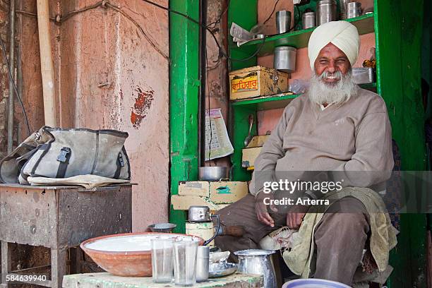 Sikh shopkeeper wearing turban selling lassi, traditional yogurt-based drink, in Jaipur, Rajasthan, India.