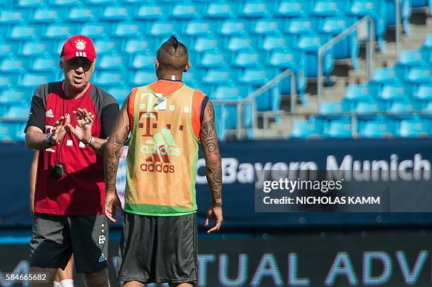 Bayern Munich's new coach Carlo Ancelotti speaks with player Arturo Vidal during a training session in Charlotte, North carolina, on July 29 on the...