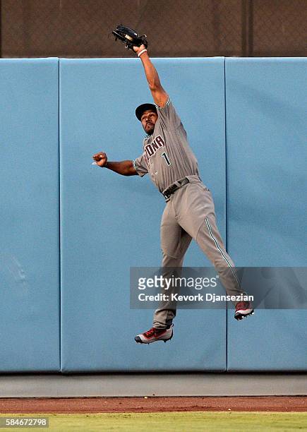 Michael Bourn of the Arizona Diamondbacks leaps to catch the baseball hit by Chase Utley of the Los Angeles Dodgers before crashing against the wall...
