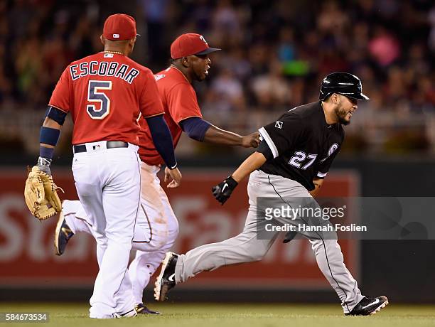 Miguel Sano of the Minnesota Twins catches Dioner Navarro of the Chicago White Sox off second base after a run-down as teammate Eduardo Escobar looks...