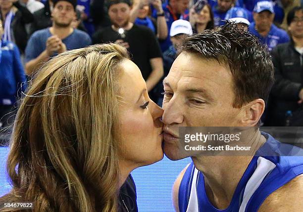 Brent Harvey of the Kangaroos kisses his partner Shayne McClintock as he runs out to play in the round 19 AFL match between the North Melbourne...