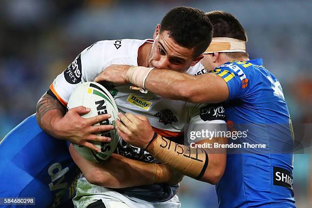 Joshua Aloiai of the Tigers is tackled by the Eels defence during the round 21 NRL match between the Parramatta Eels and the Wests Tigers at ANZ...