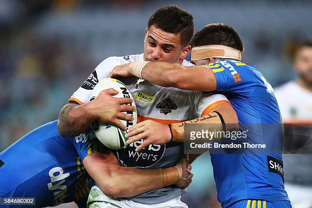 Joshua Aloiai of the Tigers is tackled by the Eels defence during the round 21 NRL match between the Parramatta Eels and the Wests Tigers at ANZ...