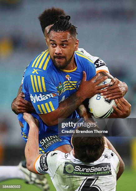 Kenneth Edwards of the Eels is tackled by Kevin Naiqama and Mitchell Moses of the Tigers during the round 21 NRL match between the Parramatta Eels...