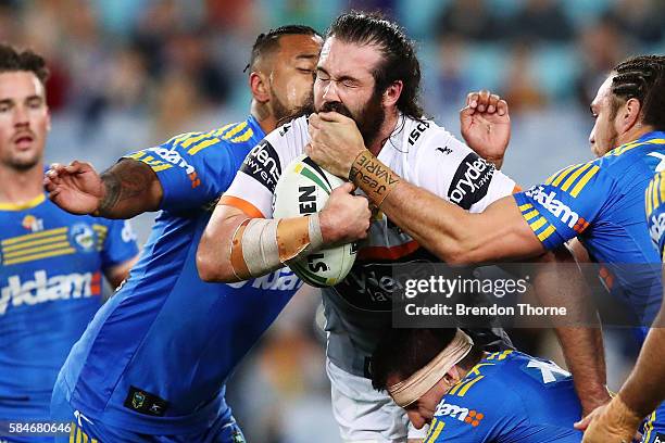 Aaron Woods of the Tigers is tackled by the Eels defence during the round 21 NRL match between the Parramatta Eels and the Wests Tigers at ANZ...