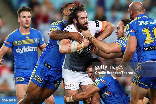 Aaron Woods of the Tigers is tackled by the Eels defence during the round 21 NRL match between the Parramatta Eels and the Wests Tigers at ANZ...