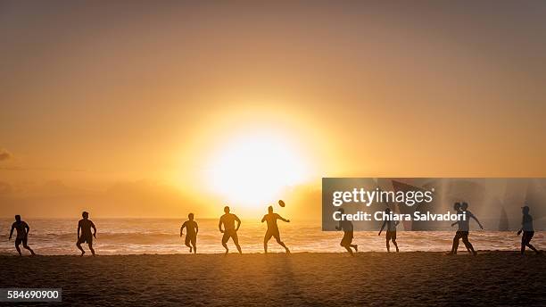 some rugby players play rugby football on the beach of camps bay, south africa - camps bay stock-fotos und bilder