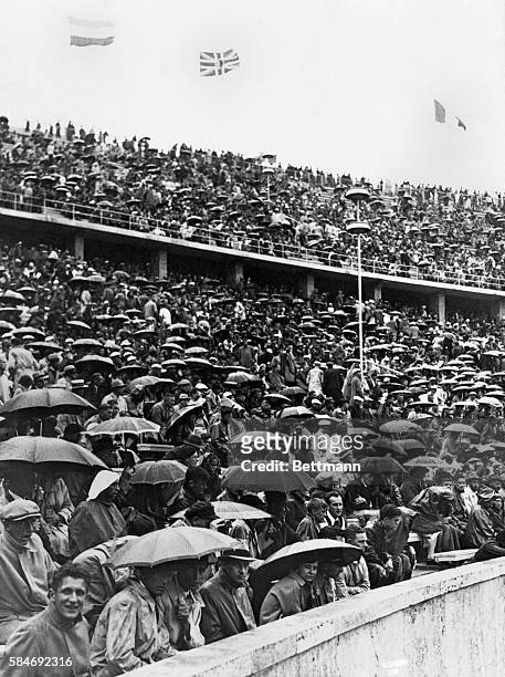 Undaunted by rain spectators jammed the Olympic Stadium, under cover of umbrellas on Monday, August 3, second day of the Olympic Games of 1936.
