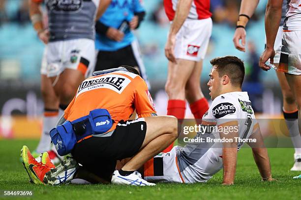 Luke Brooks of the Tigers receives attention from a trainer during the round 21 NRL match between the Parramatta Eels and the Wests Tigers at ANZ...