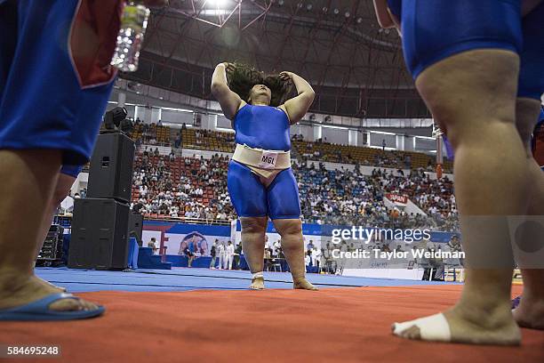 Mongolian wrestler adjusts her hair before a match during the 2016 World Sumo Championship on July 30, 2016 in Ulaanbaatar, Mongolia.