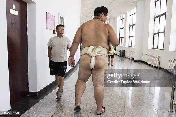 Fan checks out a wrestler as he walks toward the concessions area during the 2016 World Sumo Championship on July 30, 2016 in Ulaanbaatar, Mongolia.