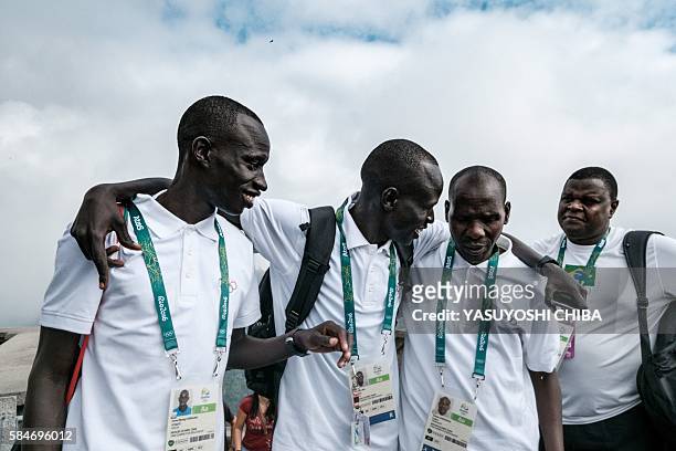 South Sudan's athlete Yiech Pur Biel and James Nyang Chiengjiek based in Kenya for the Refugee Olympic Team speak with Kenyan coach Joseph Domongole...