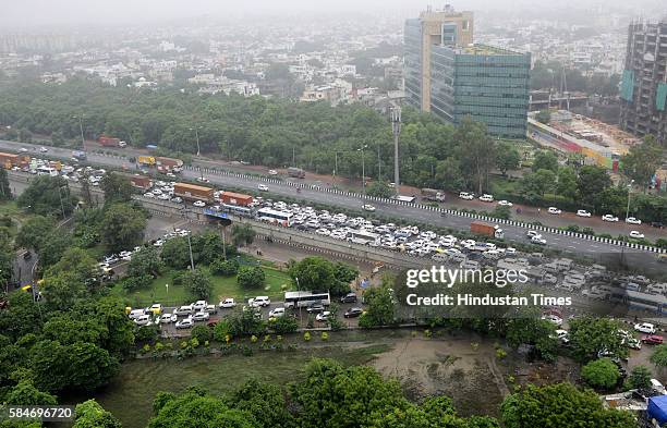 Heavy traffic jam at Signature Tower Chowk, NH8 due to heavy rainfall, as more than 150 vehicles broke-down on the highway due to water entering into...