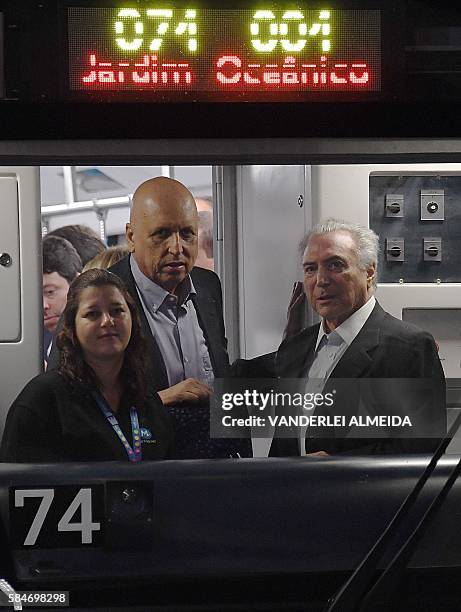 Brazil's acting president Michel Temer and Rio de Janeiro's state Governor Luiz Fernando Pezao travel on a subway train during the inauguration of...