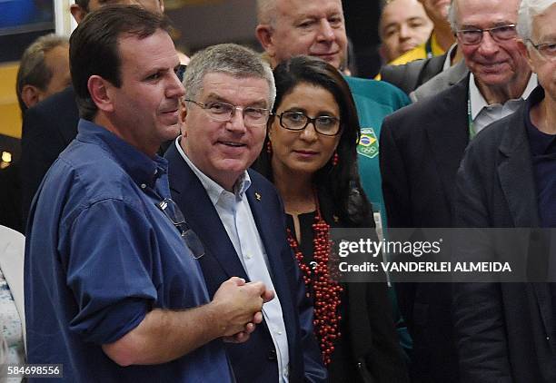 Rio de Janeiro's mayor Eduardo Paes listens to the president of the International Olympic Committee Thomas Bach during the inauguration of the Metro...