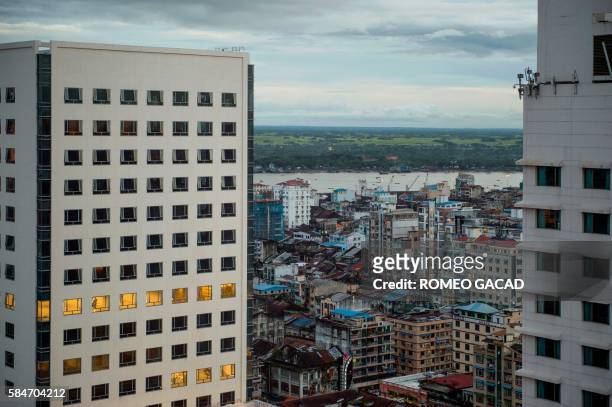 In this picture taken on July 29 two hotel high rise towers partially obscures the skyline of old Yangon with a view of Yangon river in the...