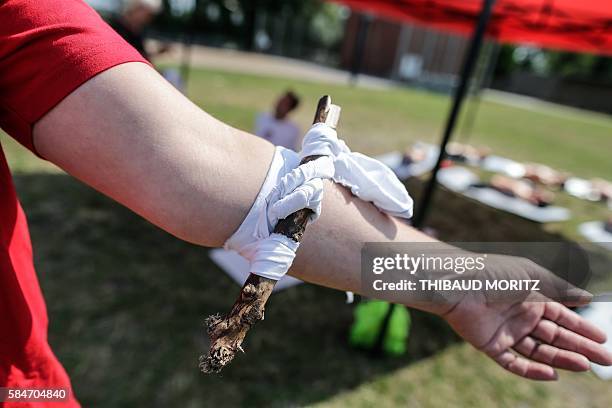 Volunteer poses with a tourniquet on his arm in Bordeaux, western France, on July 30 during a Red Cross workshop on first aid after the different...