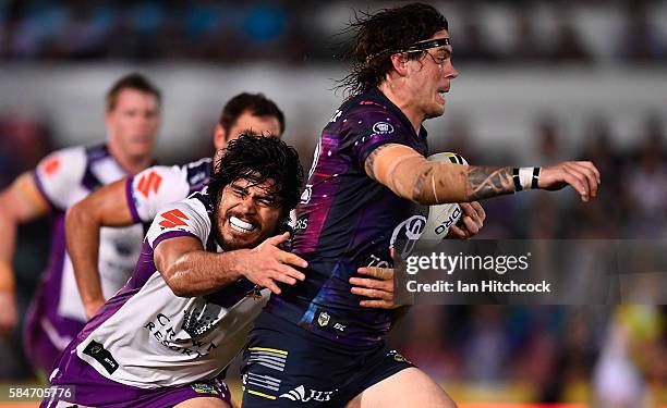 Ethan Lowe of the Cowboys is tackled by Tohu Harris of the Storm during the round 21 NRL match between the North Queensland Cowboys and the Melbourne...
