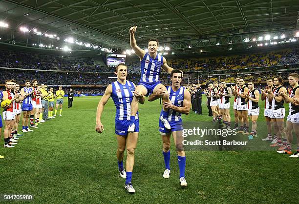 Brent Harvey of the Kangaroos is chaired from the field after the round 19 AFL match between the North Melbourne Kangaroos and the St Kilda Saints at...