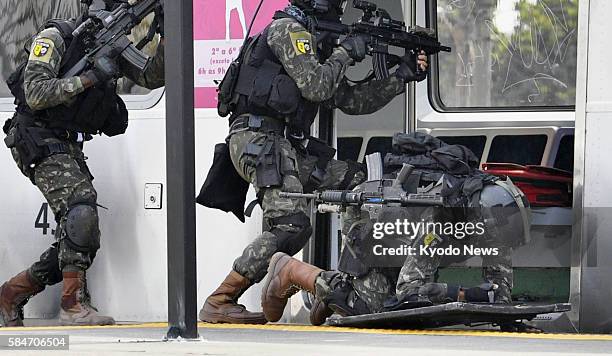 Security officer falls to the ground during a drill simulating a situation where a train has been hijacked, in Rio de Janeiro on July 16, 2016. The...