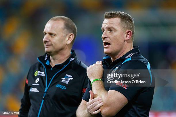 Head Coach Ken Hinkley and Assistant Michael Voss of the Power look on during the round 19 AFL match between the Brisbane Lions and the Port Adelaide...