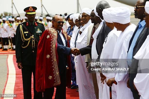 Sudanese President Omar al-Bashir greets officials upon his arrival at the airport on July 30, 2016 in the capital Khartoum. Omar al-Bashir was...