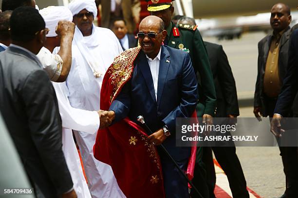 Sudanese President Omar al-Bashir greets officials upon his arrival at the airport on July 30, 2016 in the capital Khartoum. Omar al-Bashir was...