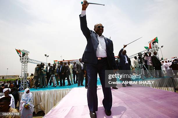 Sudanese President Omar al-Bashir greets the audience during a ceremony in his honour upon his return in the country from Ethiopa on July 30, 2016 in...