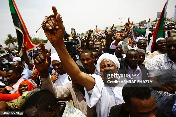 Supporters of Sudanese President shout slogans during a ceremony in his honour upon his return in the country from Ethiopia on July 30, 2016 in the...