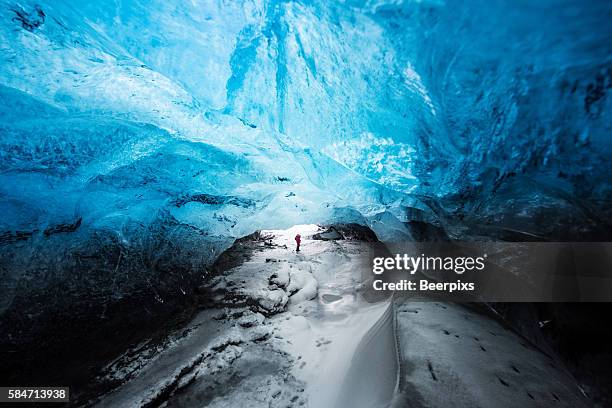 man traveler enjoying ice cave in vatnajokull glacier, iceland. - skaftafell-nationalpark stock-fotos und bilder