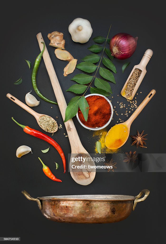 Flat lay asian or indian cuisine recipe ingredient herb and spices on black texture background.