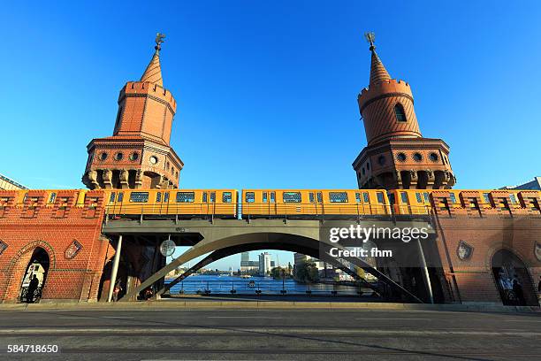 berlin kreuzberg - the "oberbaumbrücke" crossing spree river, with a passing subway train with light installation "rock, paper, scissors“ by thorsten goldberg - oberbaumbruecke stock pictures, royalty-free photos & images