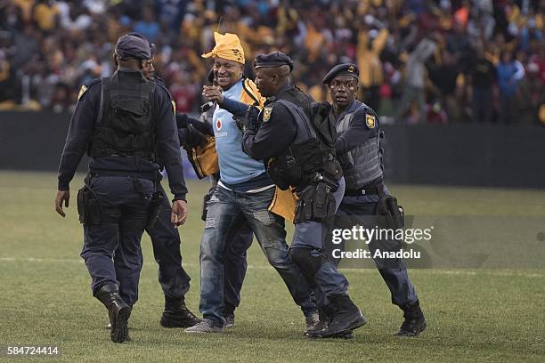 Police officer cathces a fan of Kaiser Chiefs during 2016 Carling Black Label Cup between Kaizer Chiefs F.C. And Orlando Pirates at FNB Stadium in...