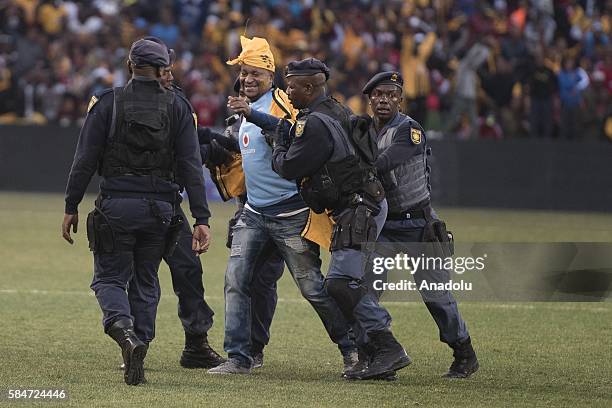 Police officer cathces a fan of Kaiser Chiefs during 2016 Carling Black Label Cup between Kaizer Chiefs F.C. And Orlando Pirates at FNB Stadium in...