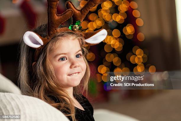 sweet little girl wears reindeer ears and antlers - haarband stockfoto's en -beelden