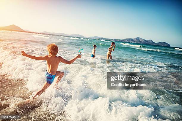 summer vacations - kids playing at sea - beach boys stock pictures, royalty-free photos & images