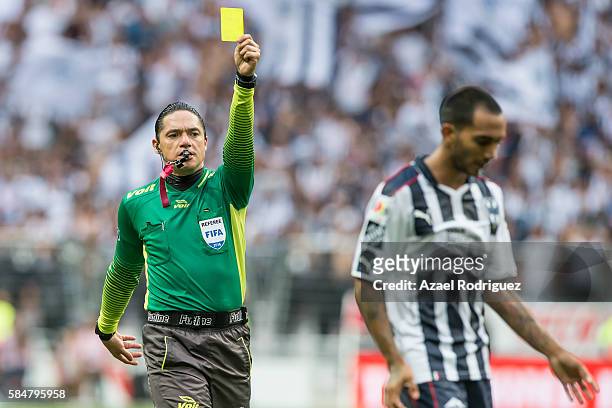 Referee Oscar Macias gives a yellow card to Edgar Castillo of Monterrey during the 3rd round match between Monterrey and Cruz Azul as part of the...