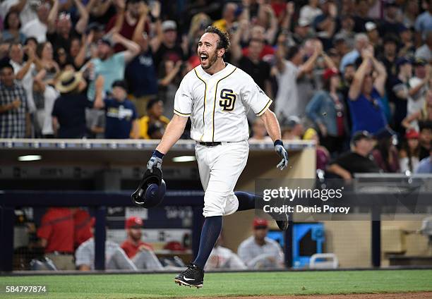 Adam Rosales of the San Diego Padres celebrates after hitting a walk-off solo home run during the tenth inning of a baseball game against the...